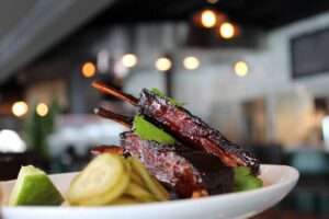 Crispy lamb ribs with sweet and spicy sauce, pickles and cilantro